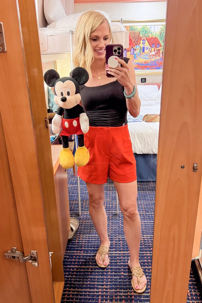 Casual cruise outfit idea with red shorts and a black tank top which looked like Mickey Mouse.