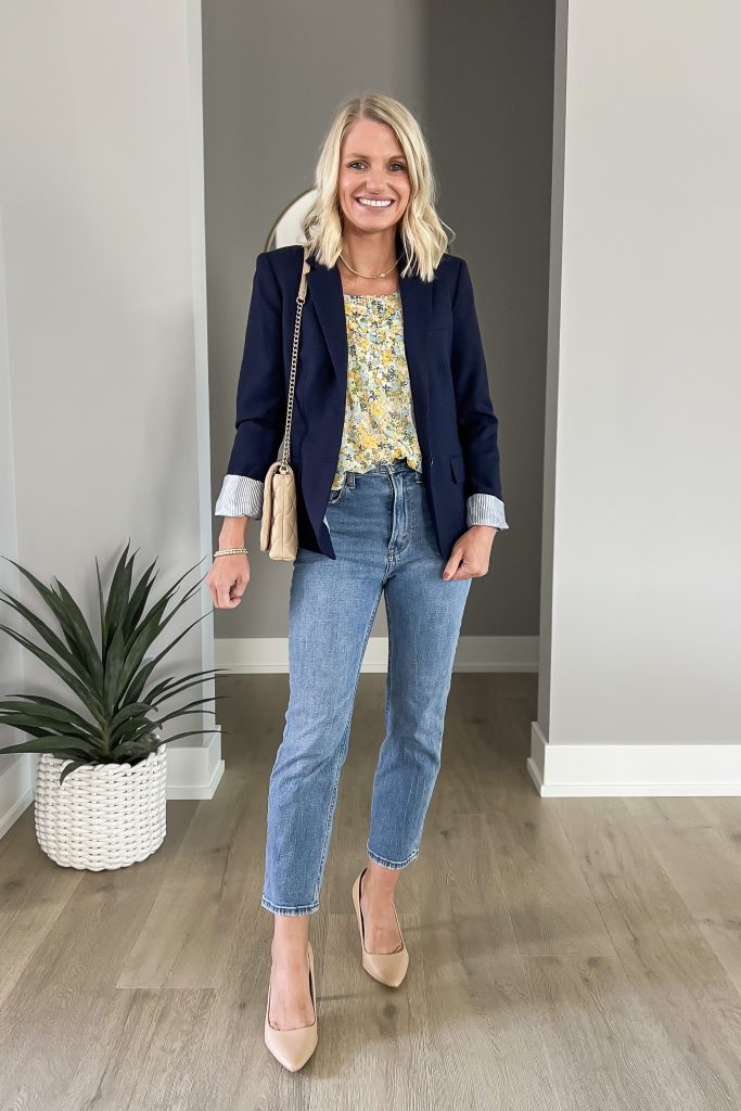 A statement blouse styled with a navy blazer and jeans.