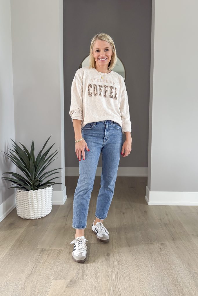 Sweatshirt with slim straight-leg cropped jeans and sneakers.