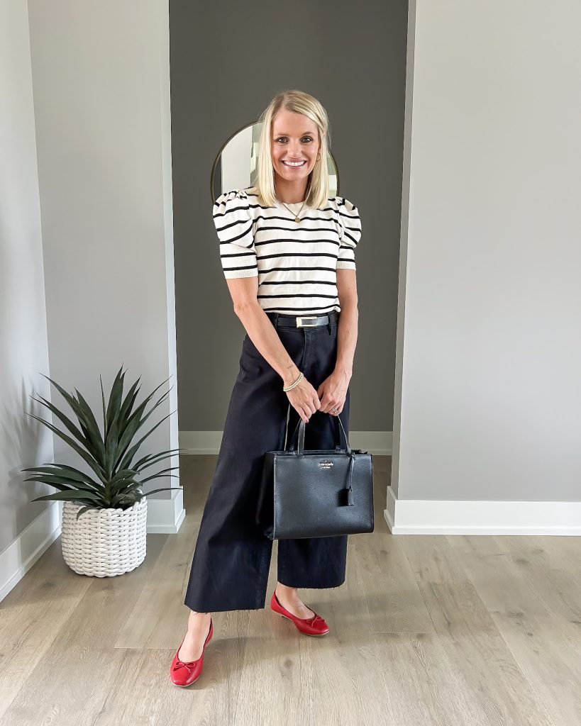 Thrifted Kate Spade purse styled with black jeans and a striped top.